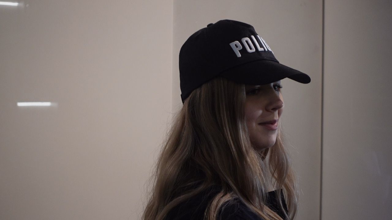 Une enquêtrice d'un jour coiffée d'une casquette « POLICE », murder party Meurtre au Stade