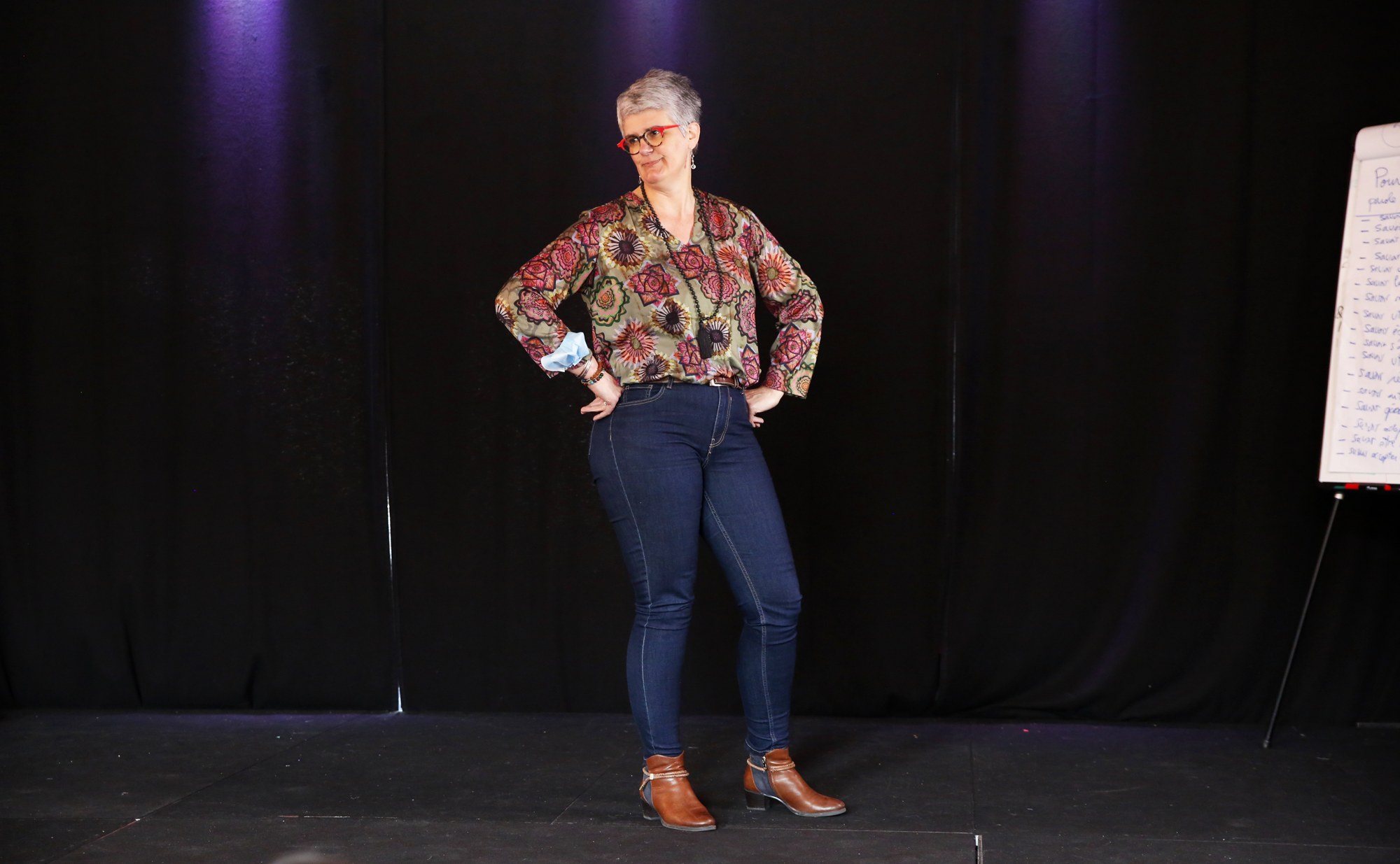 Une participante, mains sur les hanches, sourire franc, posture assurée.
